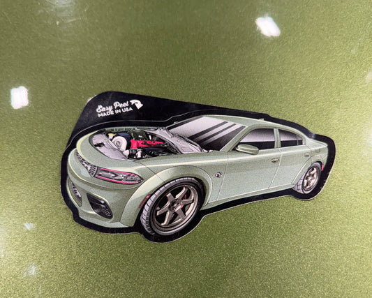 Car emblem with a logo on a green car surface